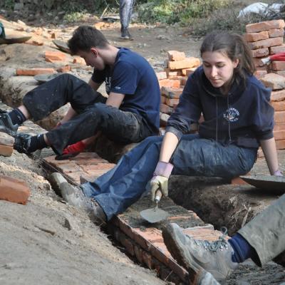 Volunteers laying bricks as part of the foundation at the Building Project in Nepal for groups Projects Abroad volunteers laying bricks to make a sturdy school at the Building Project in Nepal for groups